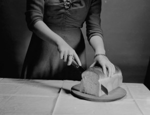 une dame coupe le pain
